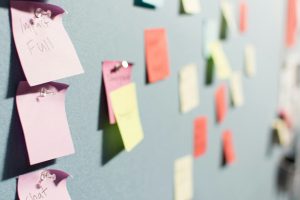 Colorful sticky notes on a blue wall, representing brainstorming and UX design processes in digital marketing strategies.