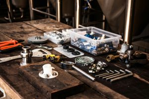 Tools and plumbing parts arranged on a wooden table, illustrating essential equipment for plumbing businesses and digital marketing strategies.