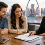 Mortgage brokers St. Louis: a couple reviews home loan papers with an advisor, Gateway Arch in the window